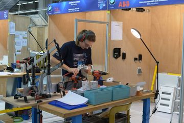 Eine junge Frau trägt einen Gehörschutz, während sie arbeitet.