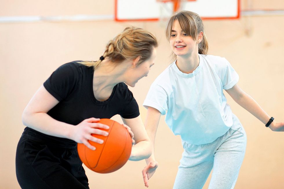 1070013492 Ein Mädchen versucht im Spiel dem anderen den Ball wegzunehmen.