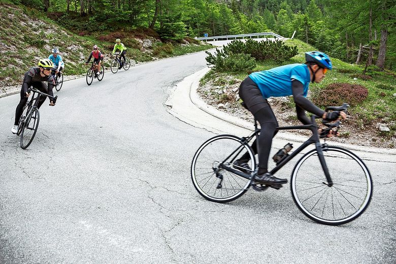 1564523086 Eine Gruppe von Velofahrerinnen und Velofahrer rast eine Kurve hinunter. Foto: istock/tomazi