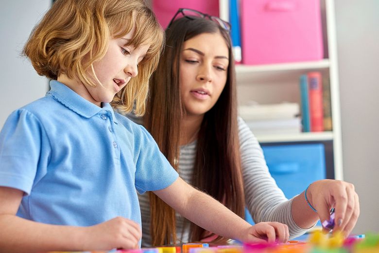 509550532 Eine Frau begleitet ein Junge beim Spielen.