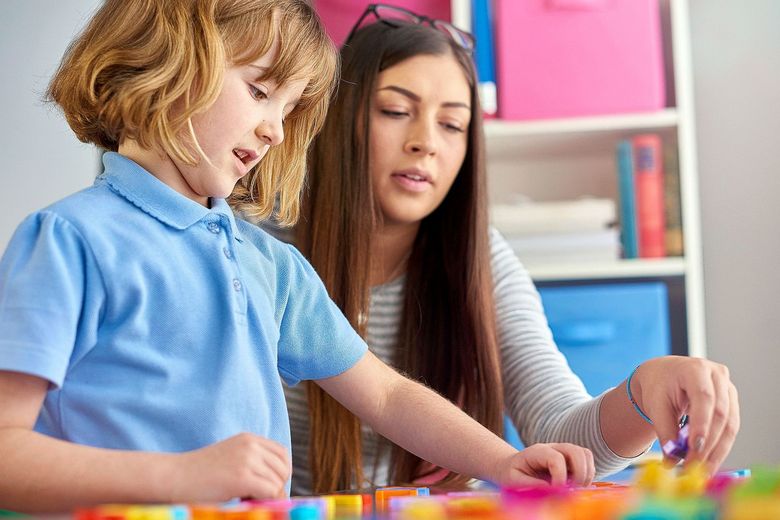 Eine Frau begleitet ein Junge beim Spielen.