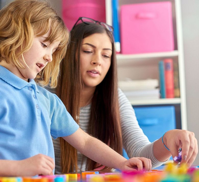Eine Frau begleitet ein Junge beim Spielen.