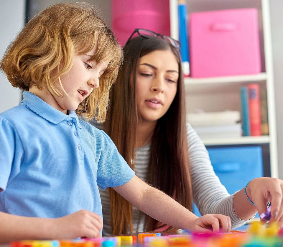 Eine Frau begleitet ein Junge beim Spielen.