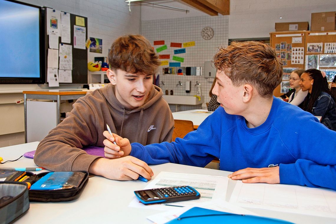 Zwei Schüler besprechen ihre Französischtexte.