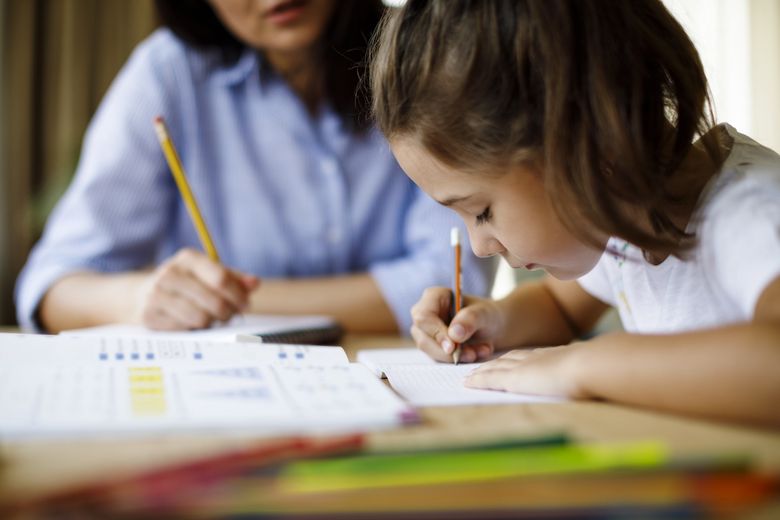 Mutter hilft Tochter bei den Hausaufgaben