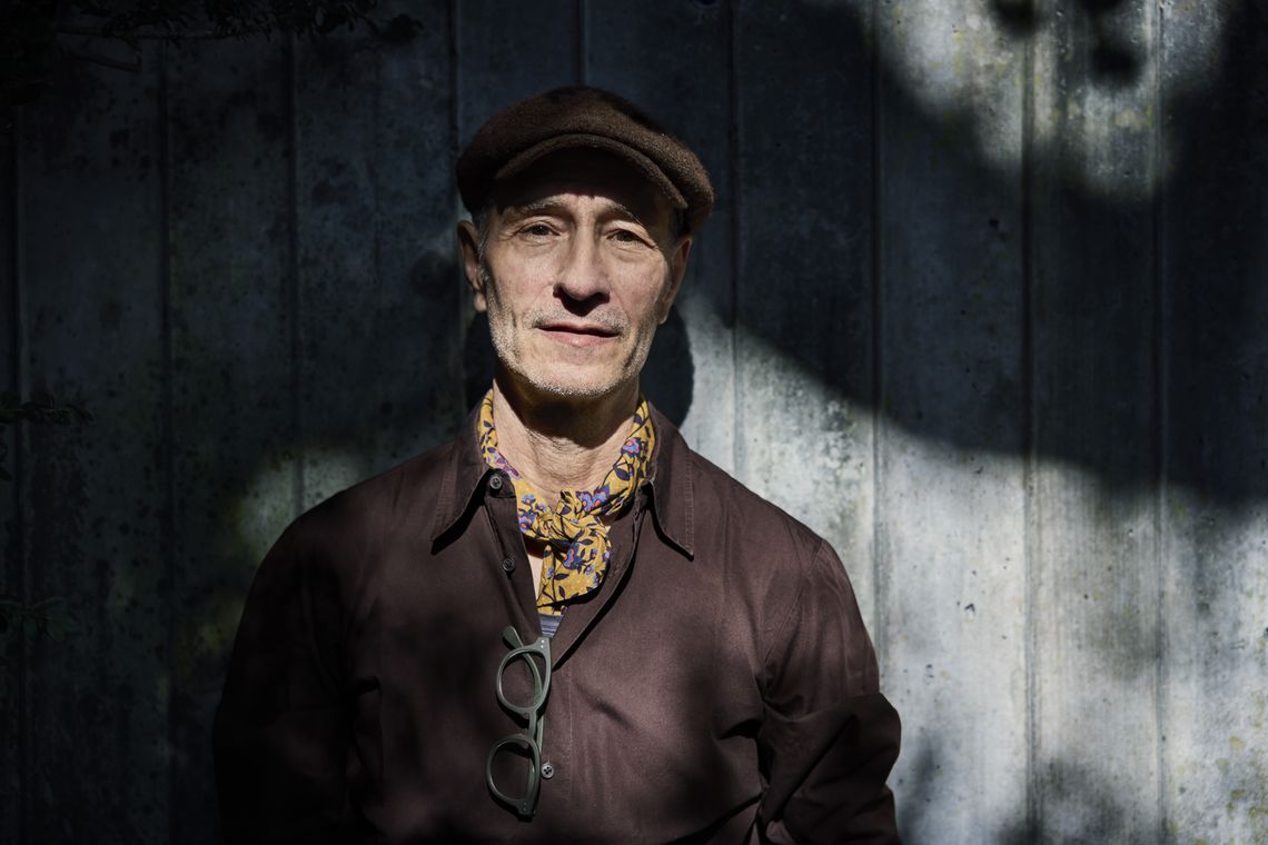 Kinderbuchautor Daniele Meocci steht im Halbschatten vor einer Betonwand.