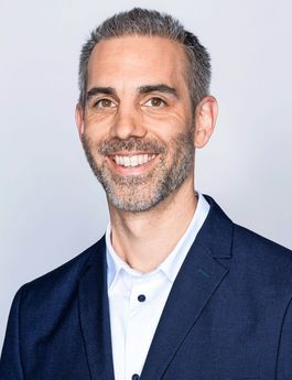 Ein Porträtfoto von Yves Karlen. Er hat einen gräulichen Bart.