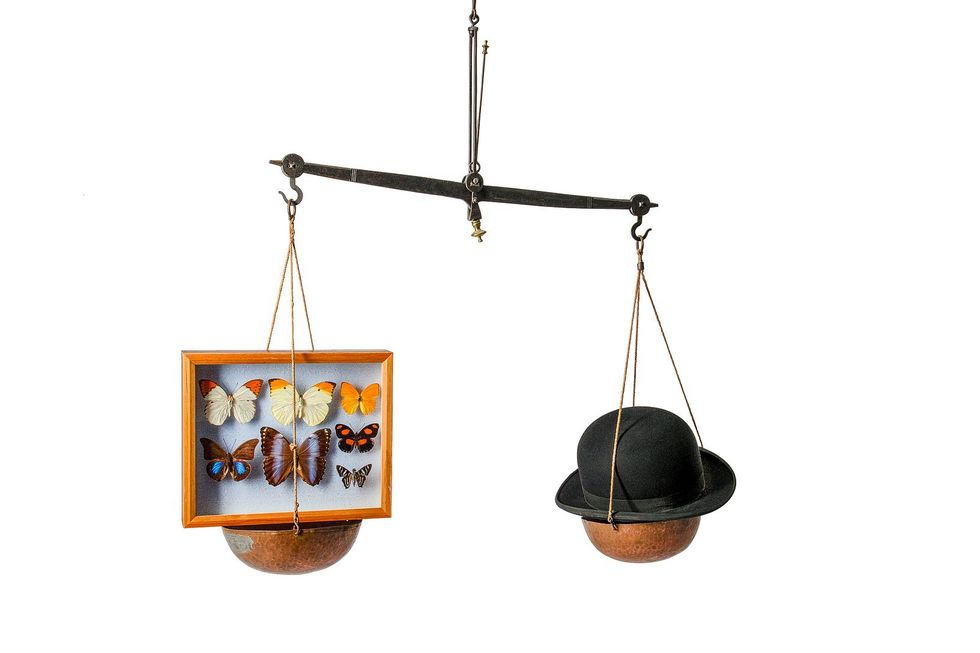Ein Hut und ein Schmetterling halten sich die Waage.