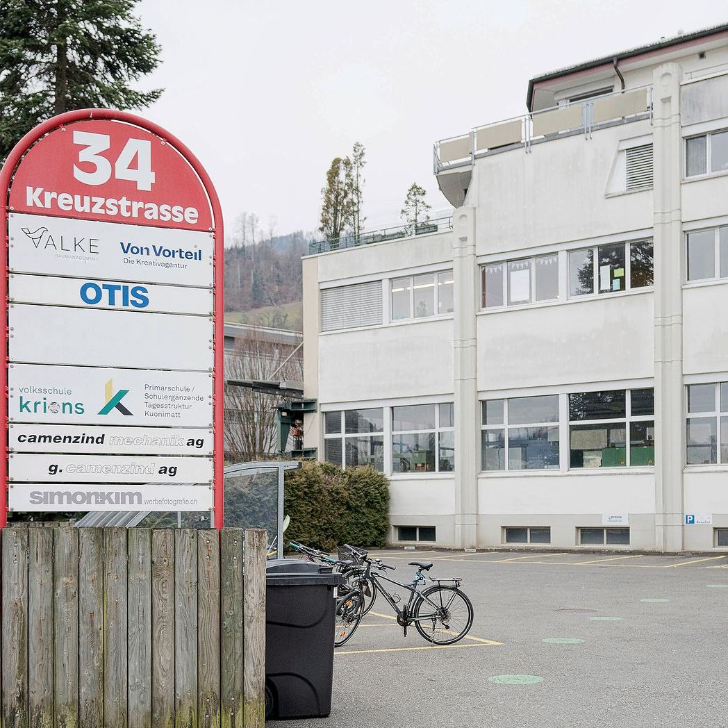 Am Schild an der Einfahrt zum Industriegebäude prängen mehrere Firmennamen und der Name einer Schule.