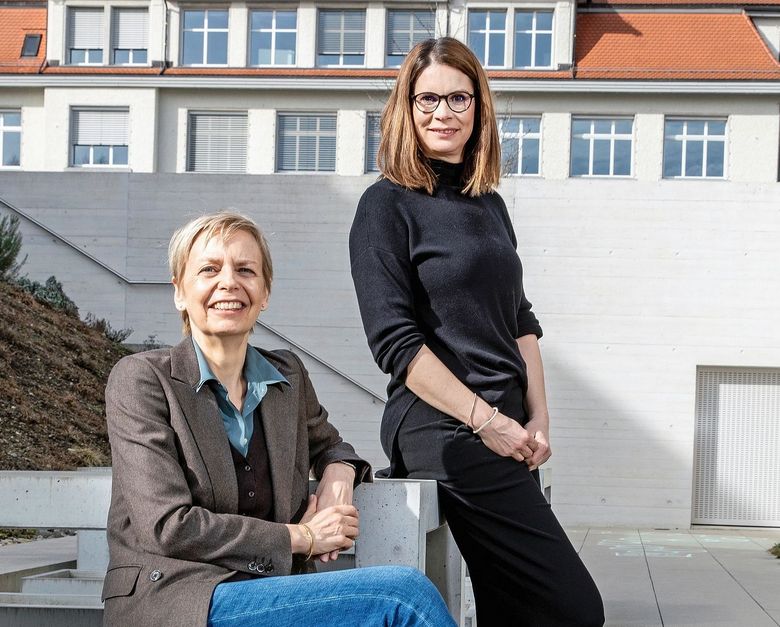 Sabina Larcher und Benita Affolter sitzen in einem Innenhof.