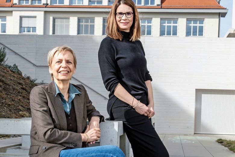 Sabina Larcher und Benita Affolter sitzen in einem Innenhof.