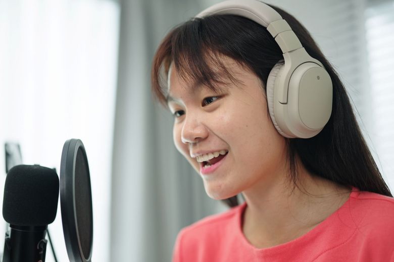 Ein Kind macht eine Podcast-Aufnahme am Mikrofon..