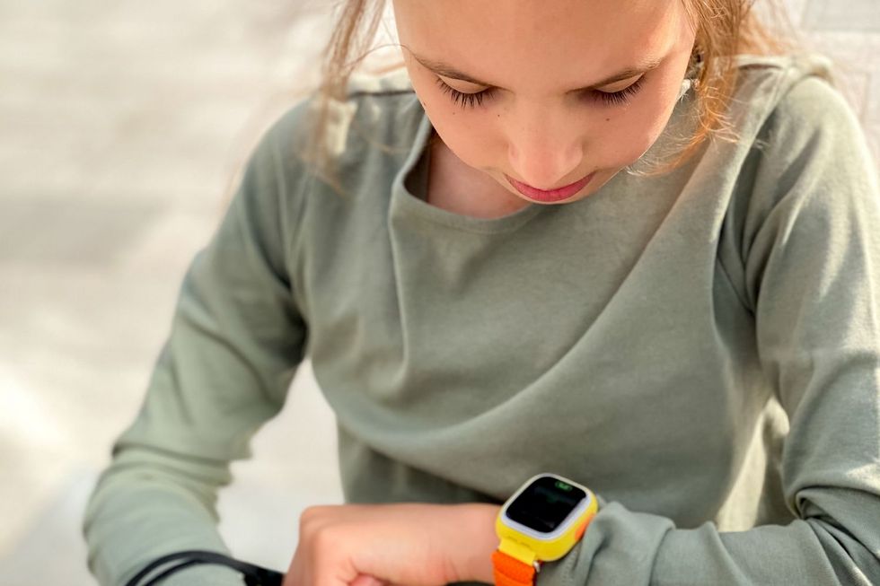 Mädchen blickt auf eine Smartwatch.