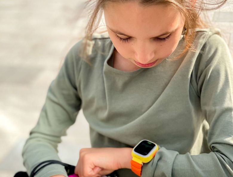 Mädchen blickt auf eine Smartwatch.
