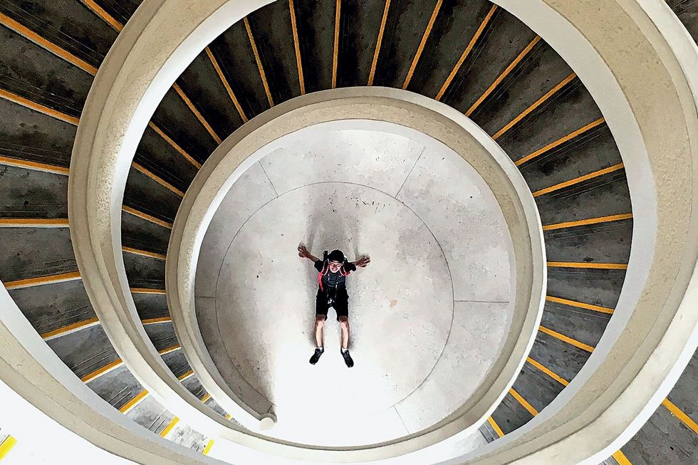 High Angle View Of Man At Bottom Of Spiral Staircase