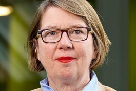 Frau in braunem Blazer.