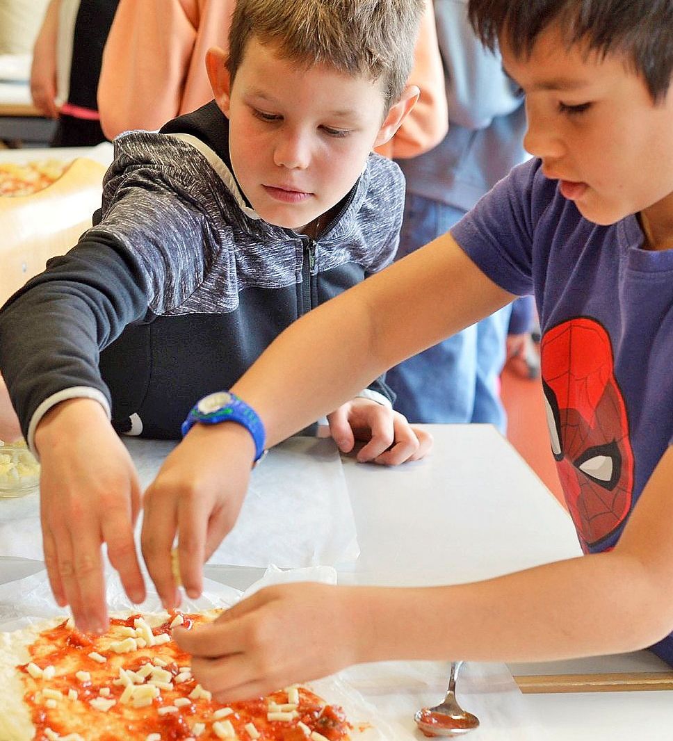 Kinder machen Pizza.