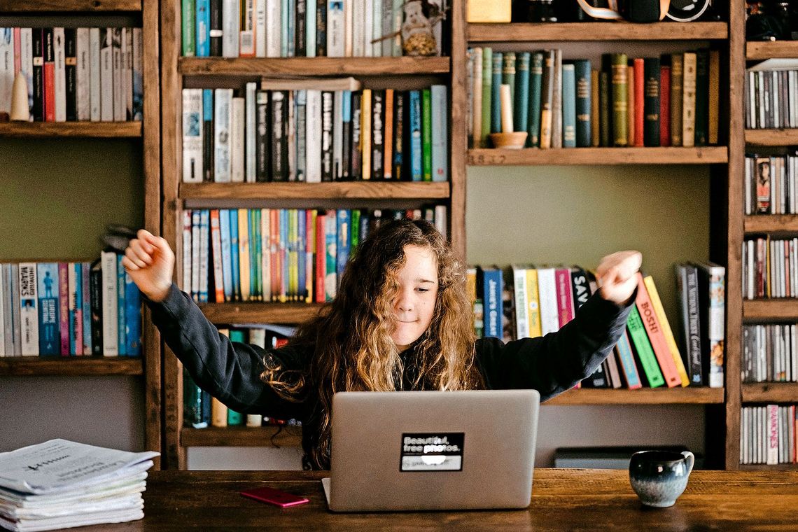 Eine Schülerin frohlockt am Laptop.