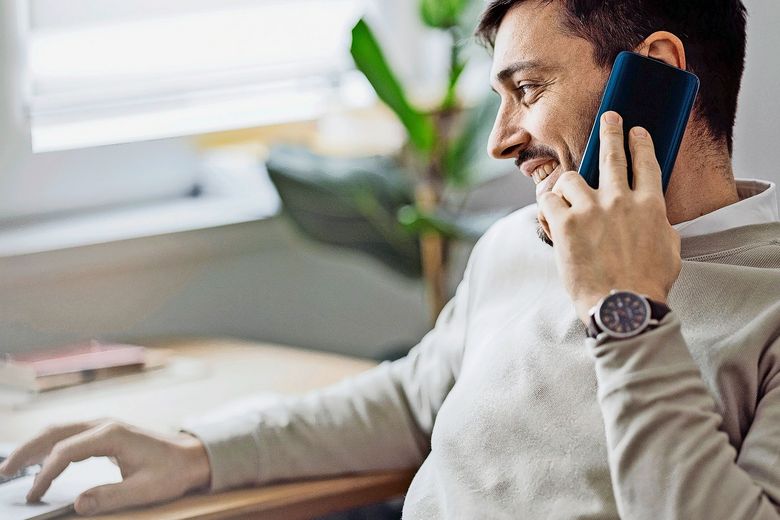 Home Office: An Anonymous Man Using a Laptop for Online Trading While Working From Home