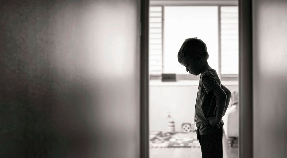 1277214443 Sad boy standing alone in the hallway