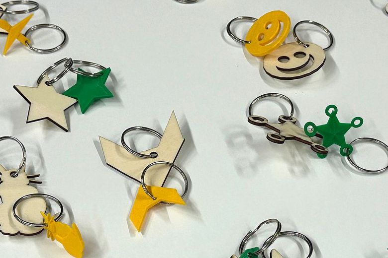 Mehrere Schlüsselanhänger in Form von Smileys, Sternen und anderen Symbolen liegen auf einem Tisch.