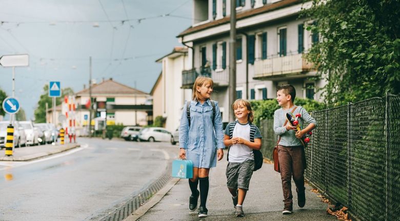 Drei Kinder unterwegs auf dem Trottoir