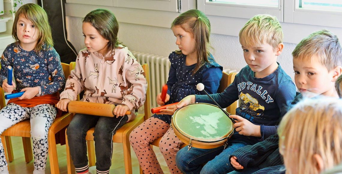 Kinder singen im Kreis.