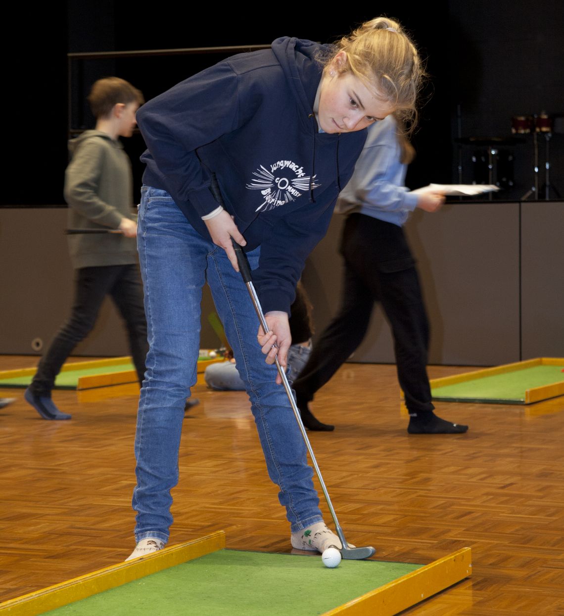 Ein Mädchen spielt Minigolf.