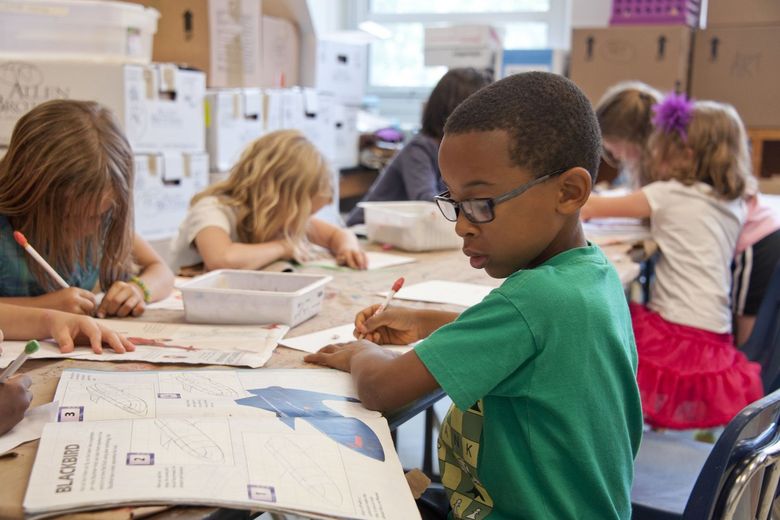 Kinder sitzen am Tisch und lernen. 