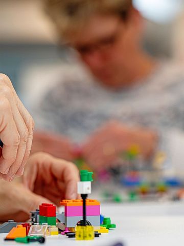 Jemand baut ein Legomodell.