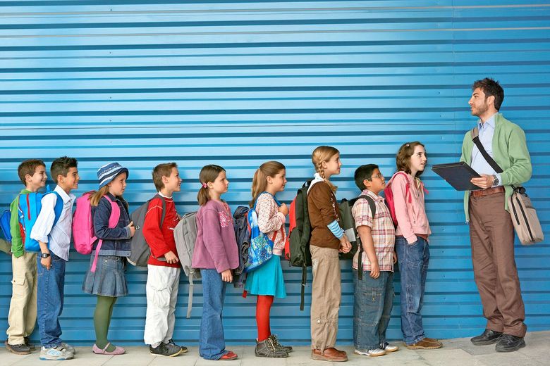 200461411-001 Ein Lehrer hat die Klasse vor sich in einer Reihe und zählt, ob alle da sind.