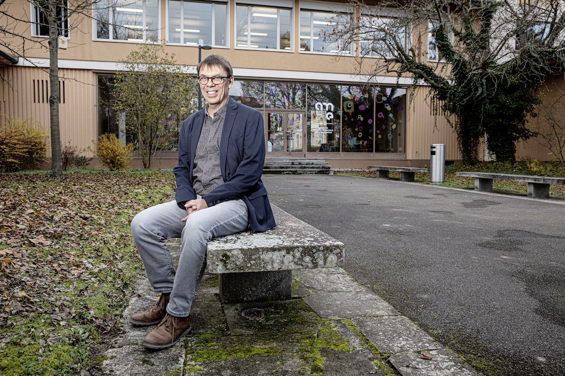 Pascal Frey sitzt vor der Schule, in der er unterrichtet.