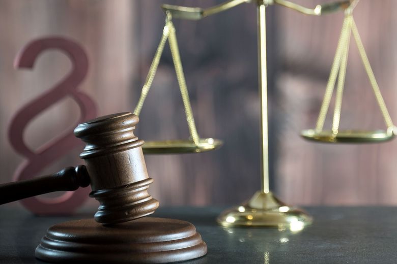 Hammer, Waage und Paragraf als Symbole für Rechtssprechung.