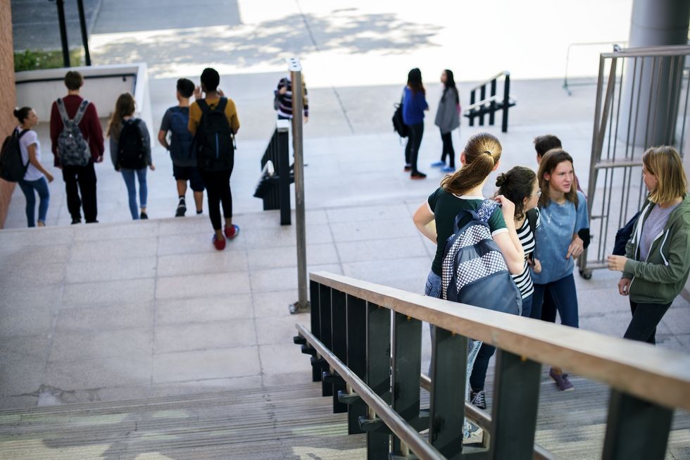 Schülerinnen und Schüler tummlen sich auf der Treppe.