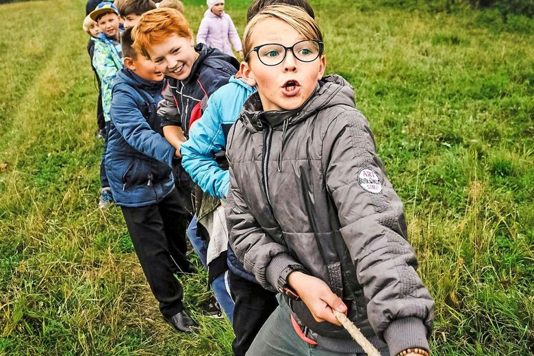 Mehrere Kinder ziehen gemeinsam an einem Seil.