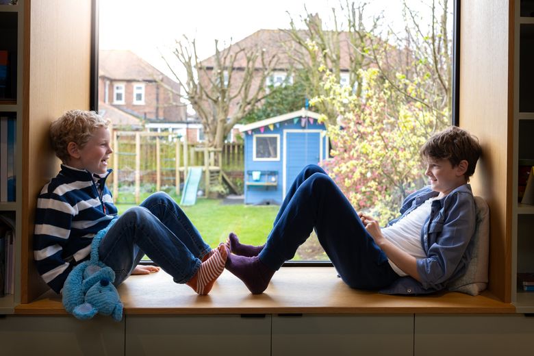 Brothers Having Fun zwei Knaben sitzen auf einer Fensterbank