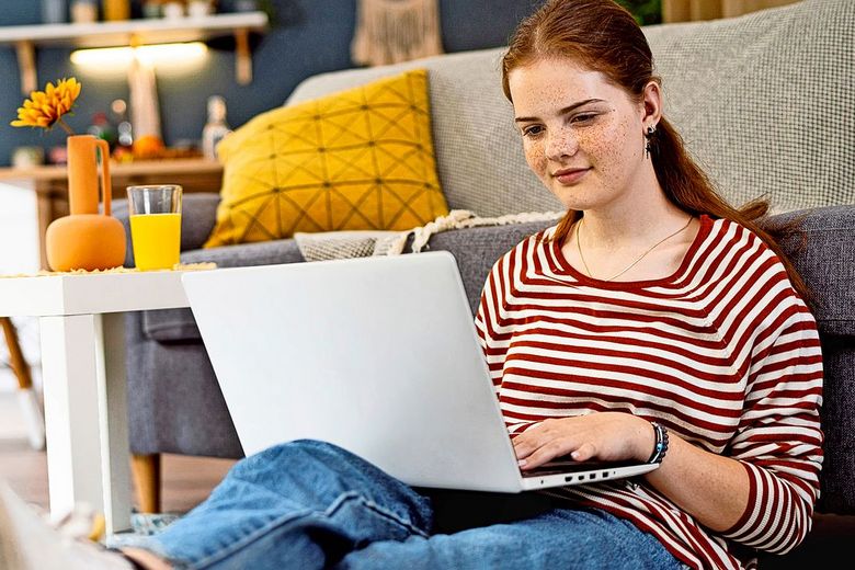 Eine junge Frau benutzt ihren Laptop.