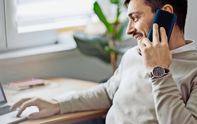 Home Office: An Anonymous Man Using a Laptop for Online Trading While Working From Home