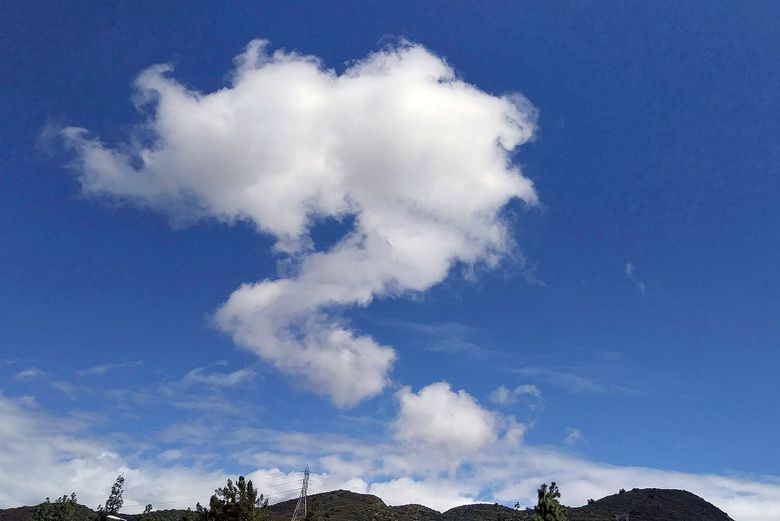 Eine Wolke in der Form eines Fragezeichens an einem blauen Himmel