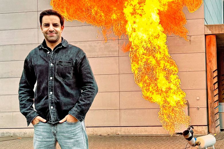 Ein Mann steht vor einem Feuerball.