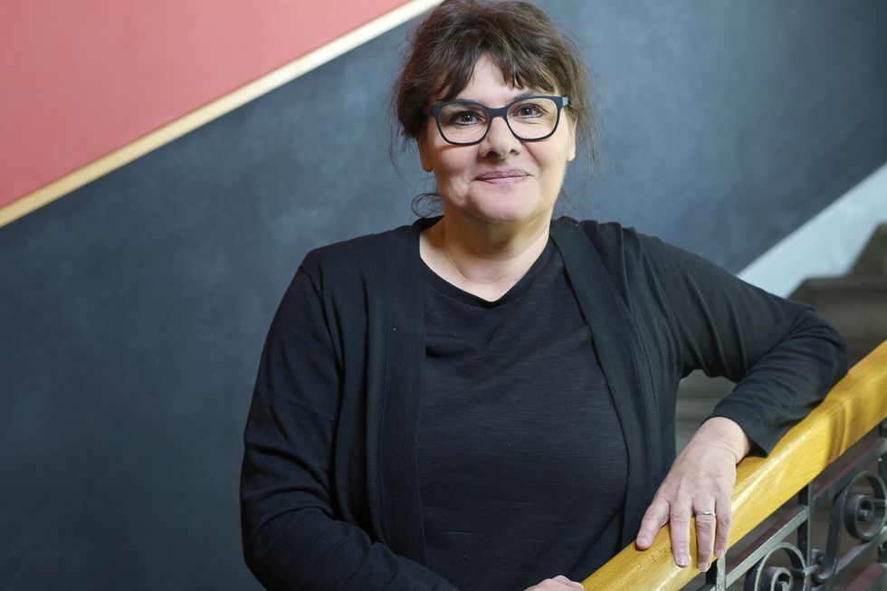 Ursula Bähler, Professorin für französische Literatur, lehnt an einem Treppengeländer.
