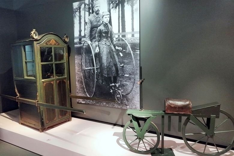 Eine Sänfte und ein Laufrad aus der Ausstellung "Ausser Gebrauch". 