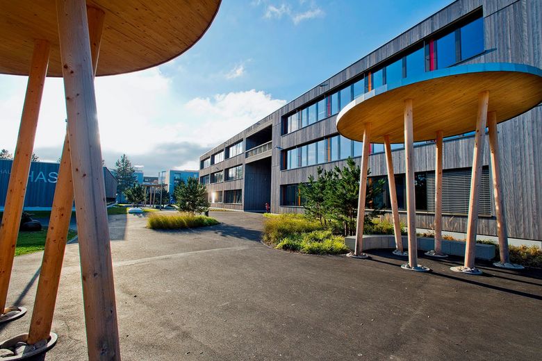Ein modernes Schulhaus mit Vorplatz.