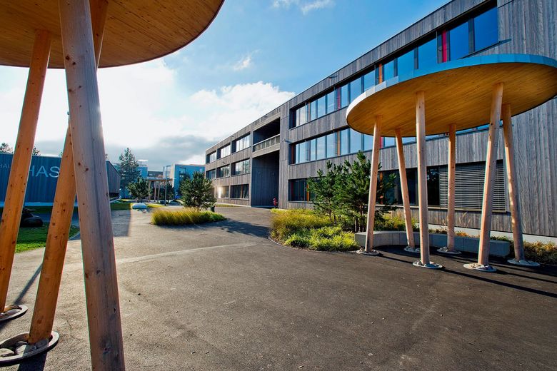 Ein modernes Schulhaus mit Vorplatz.