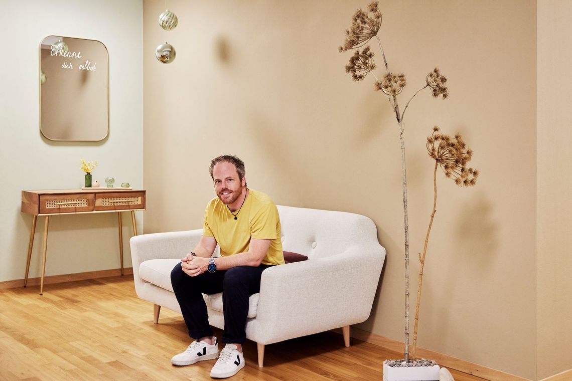 Lars Ziörjen sitzt auf einem Sofa.