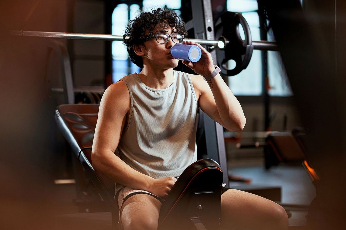 Junger Mann macht im Gym eine Trinkpause.