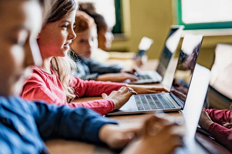 Kinder lesen an ihren Computern.