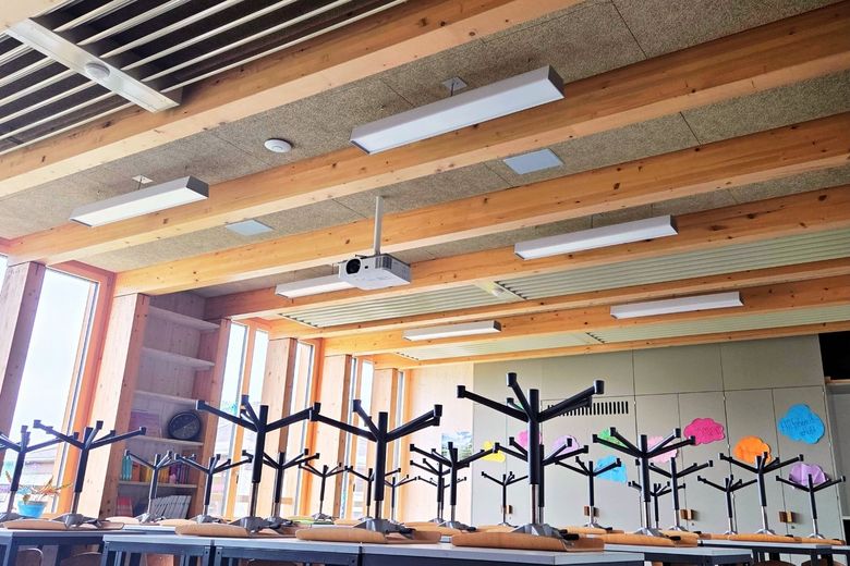 Ein Schulzimmer mit weissen Kühlgeräten an der Decke.